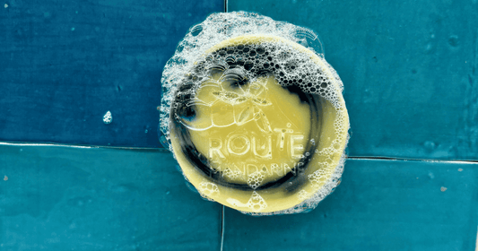 Savon solide Route Mandarine fixé avec un porte savon aimanté sur un carrelage bleu