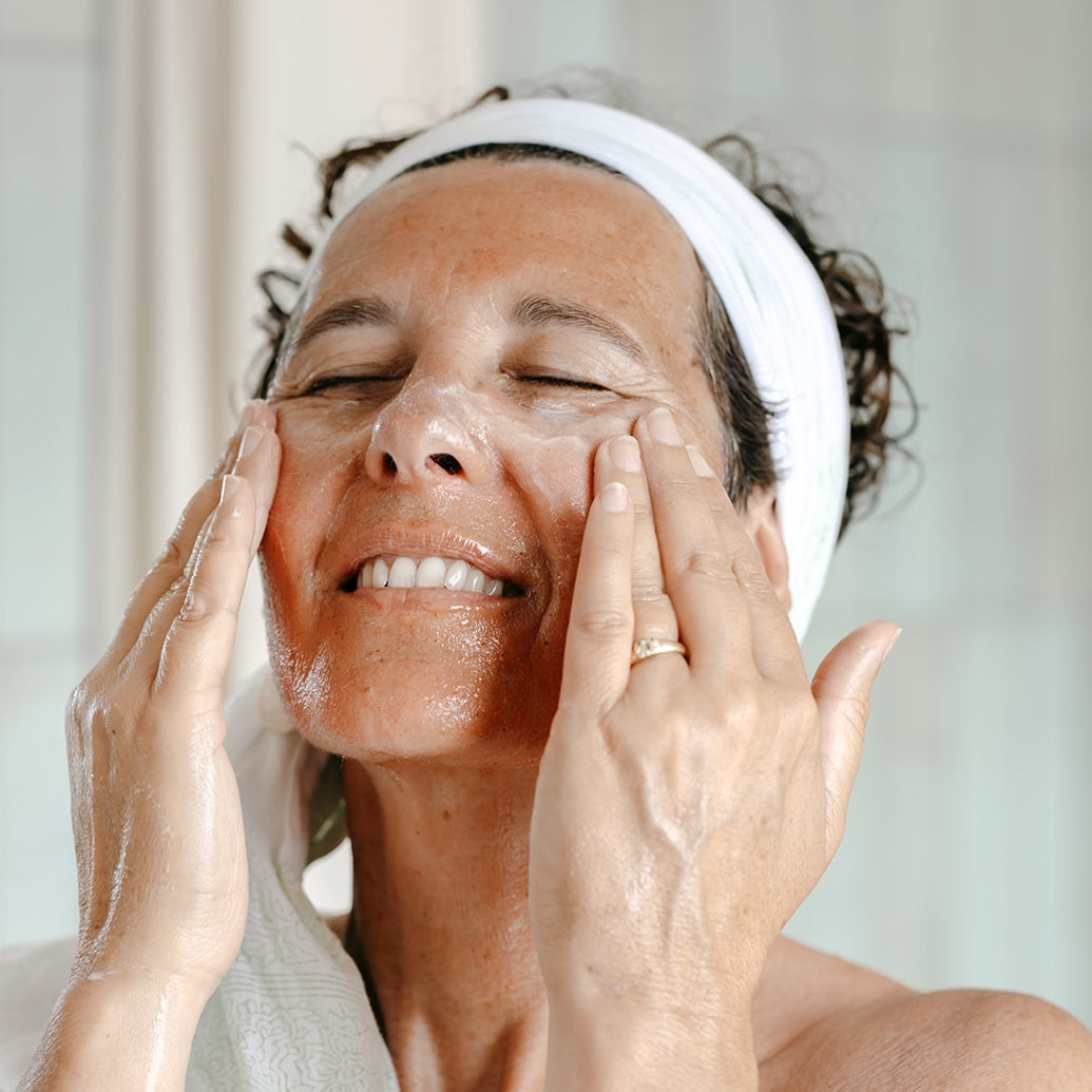 Femme souriante qui applique le soin visage route mandarine naturel et bio produit en Bretagne