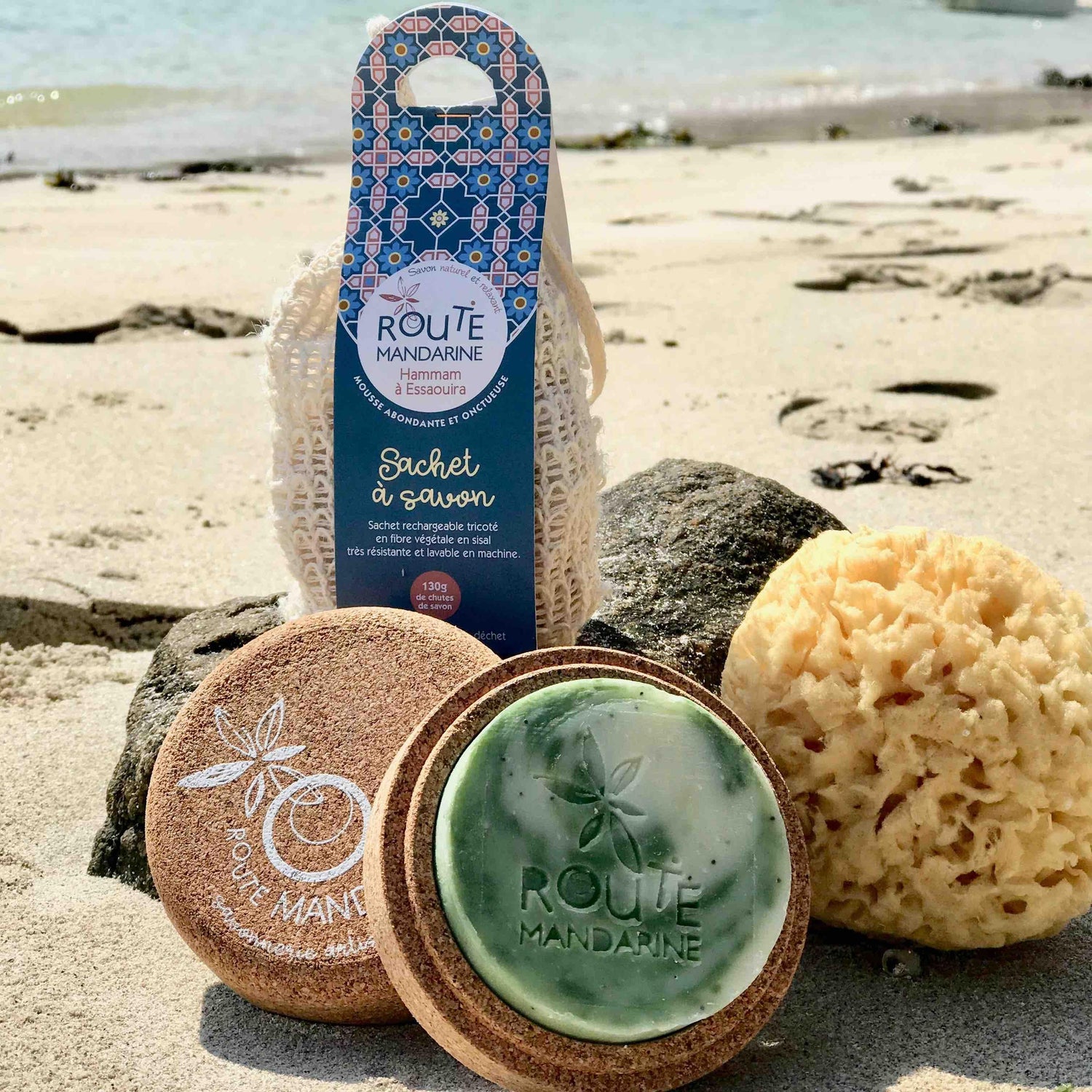 Sachet à savon boite de voyage éponge naturelle sur une plage