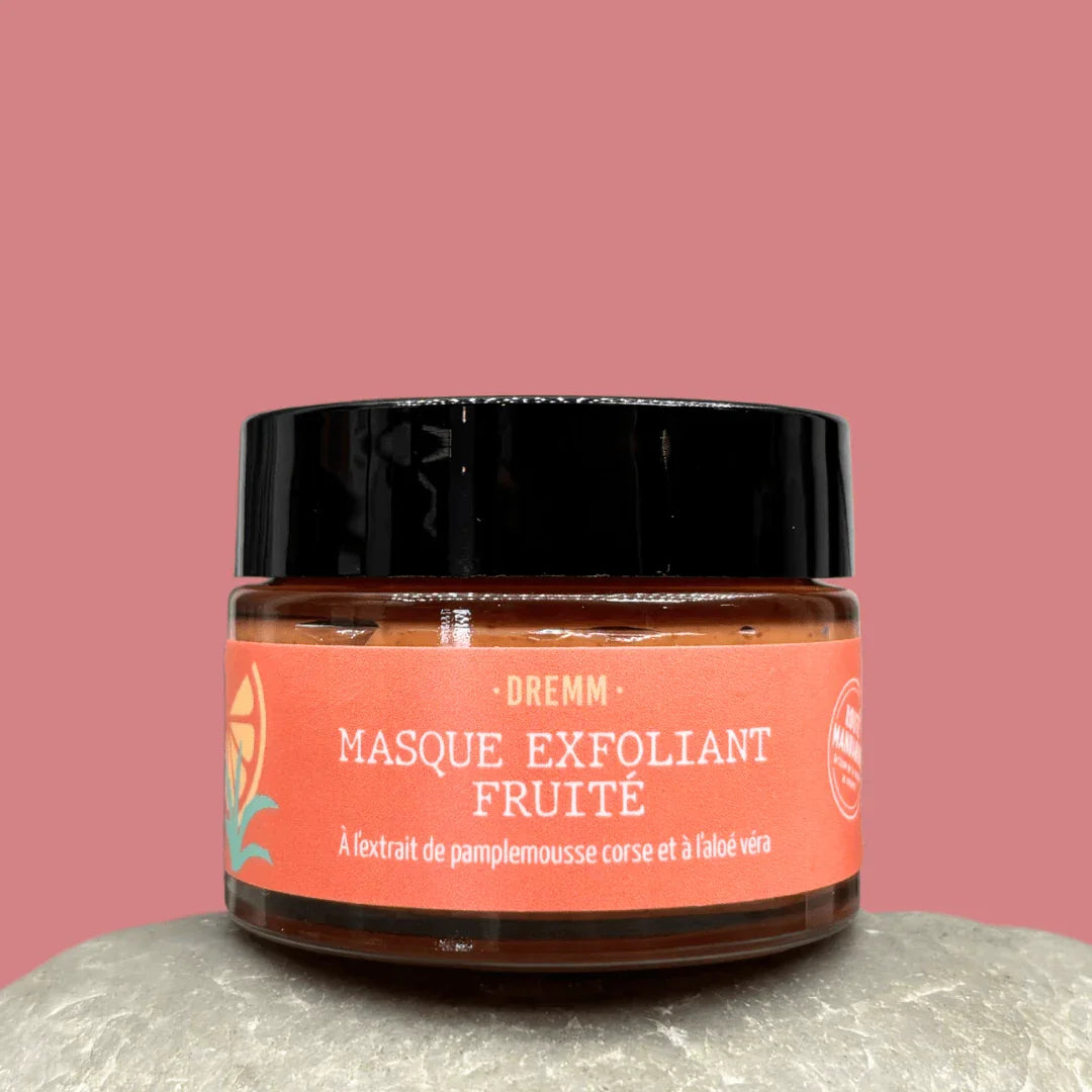 gommage visage nourrissant et fruité DREMM en pot en verre transparent, fermé, sur fond rose uni