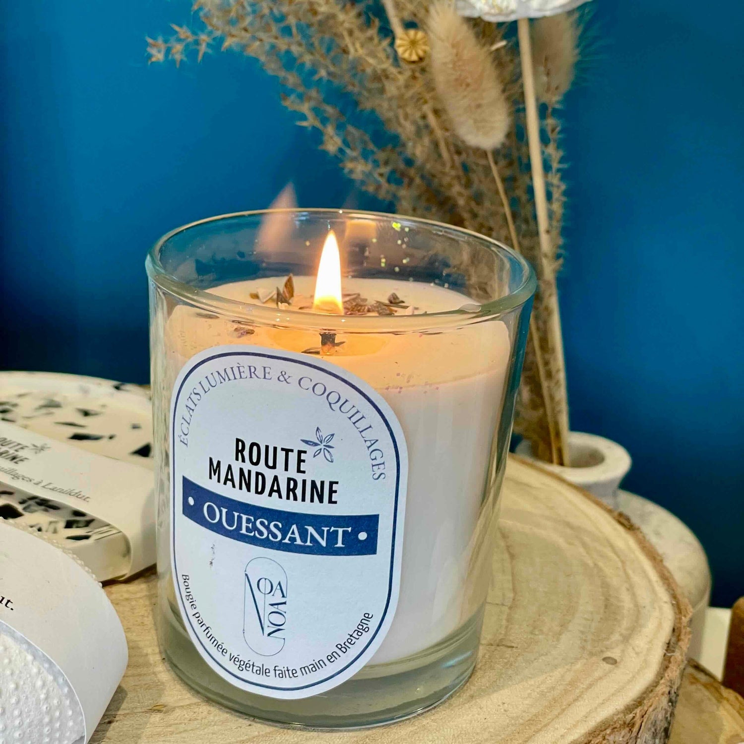 Bougie Ouessant en cire végétale allumée dans un décor bleu et bois