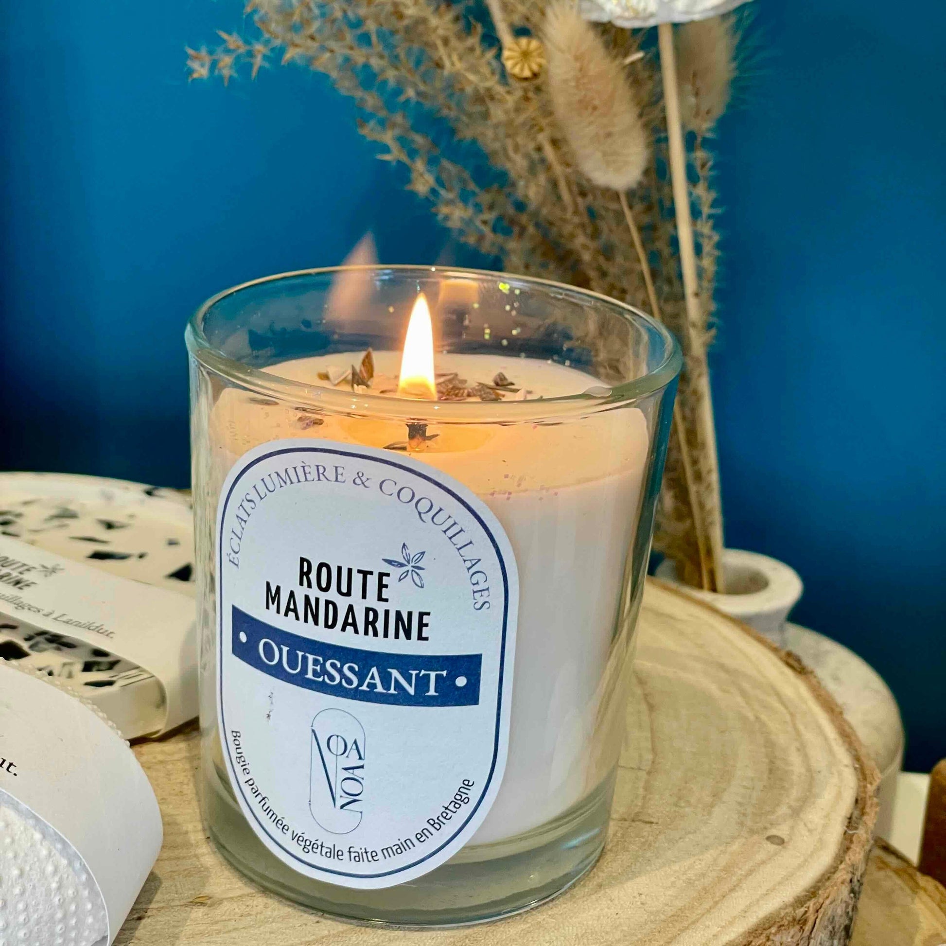Bougie Ouessant en cire végétale allumée dans un décor bleu et bois