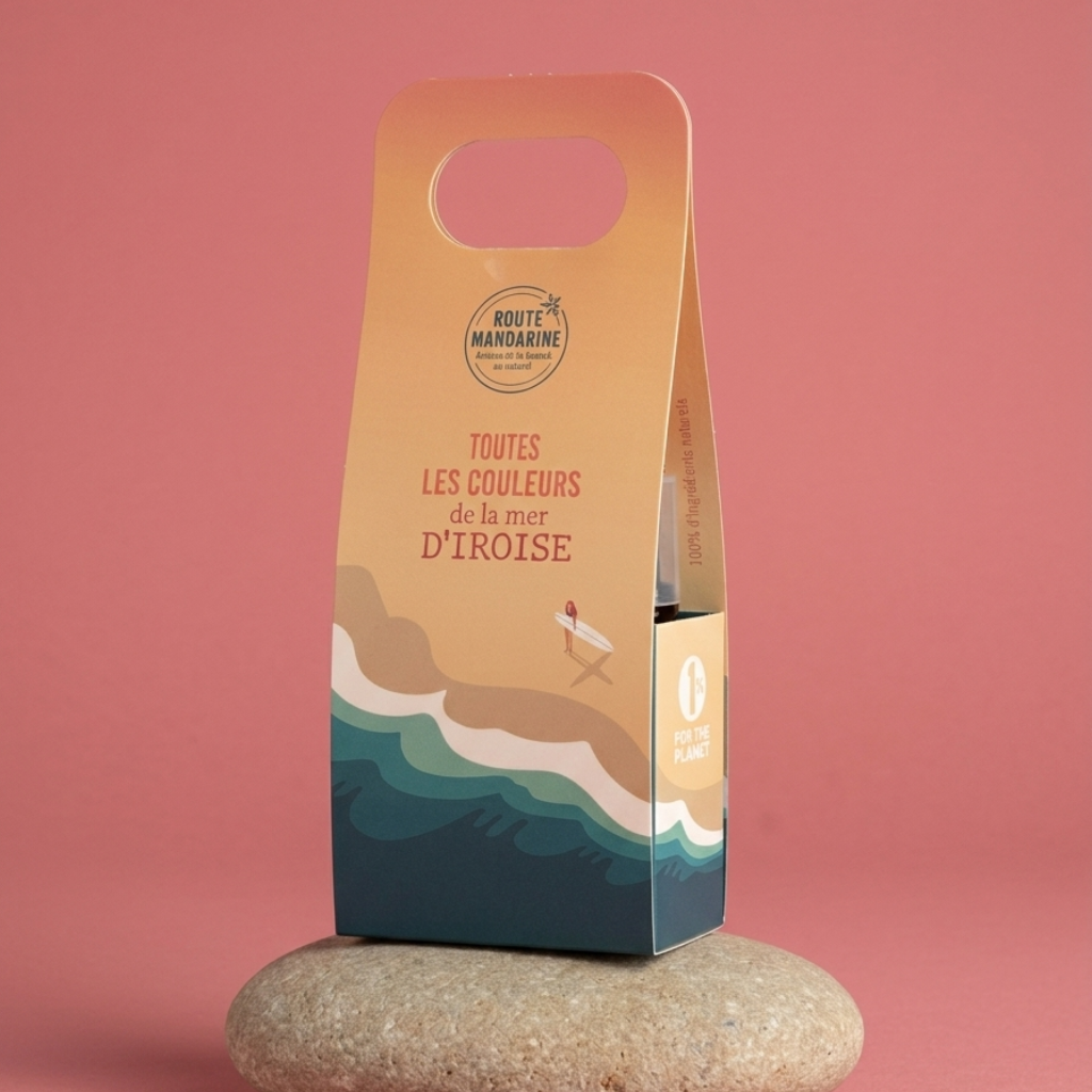 Le coffret dune et écume format voyage sur un galet et avec un fond uni rose